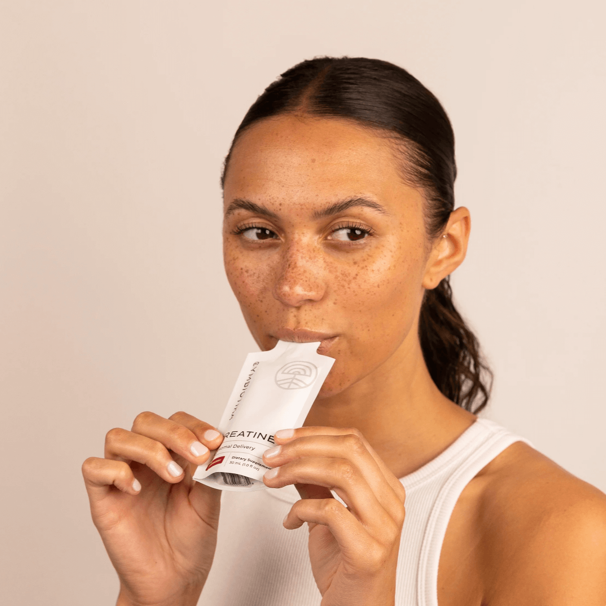 Image of woman eating  Cymbiotika Creatine Packets