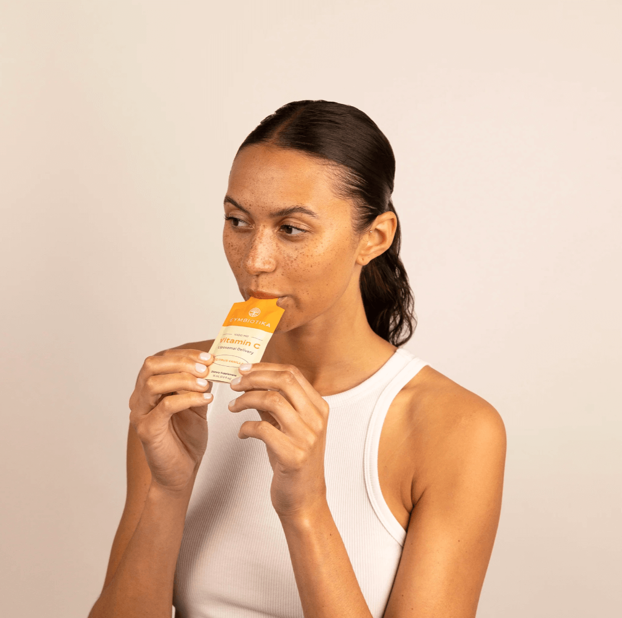 Image of woman eating cymbiotika liposomal vitamin C packets