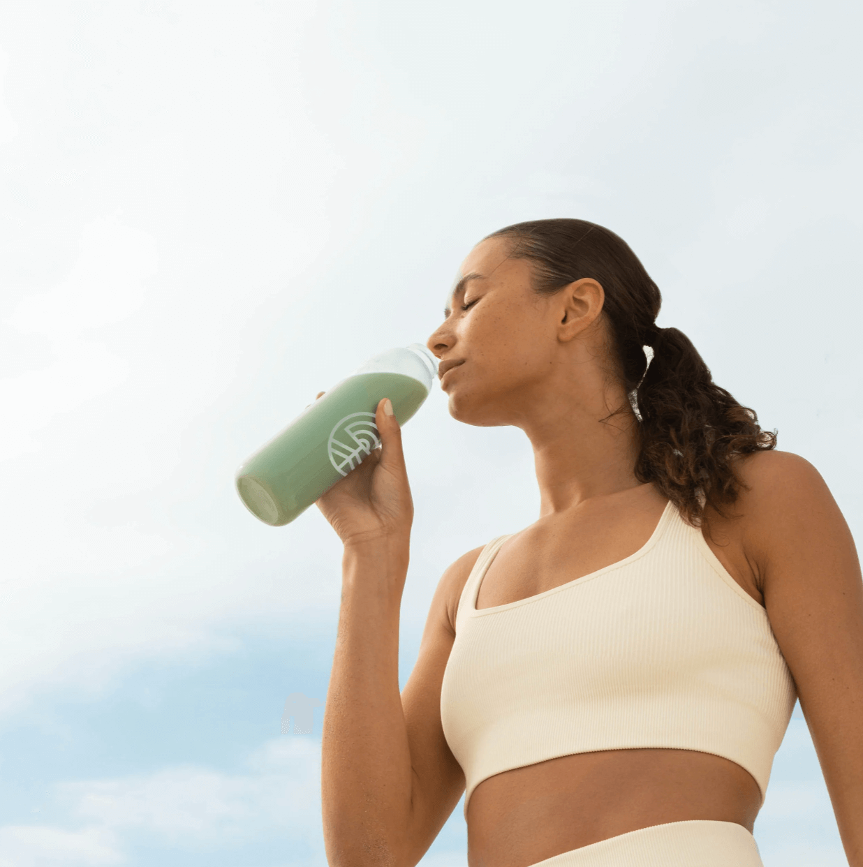 Woman drinking Cymbiotika Plant Protein Pouch