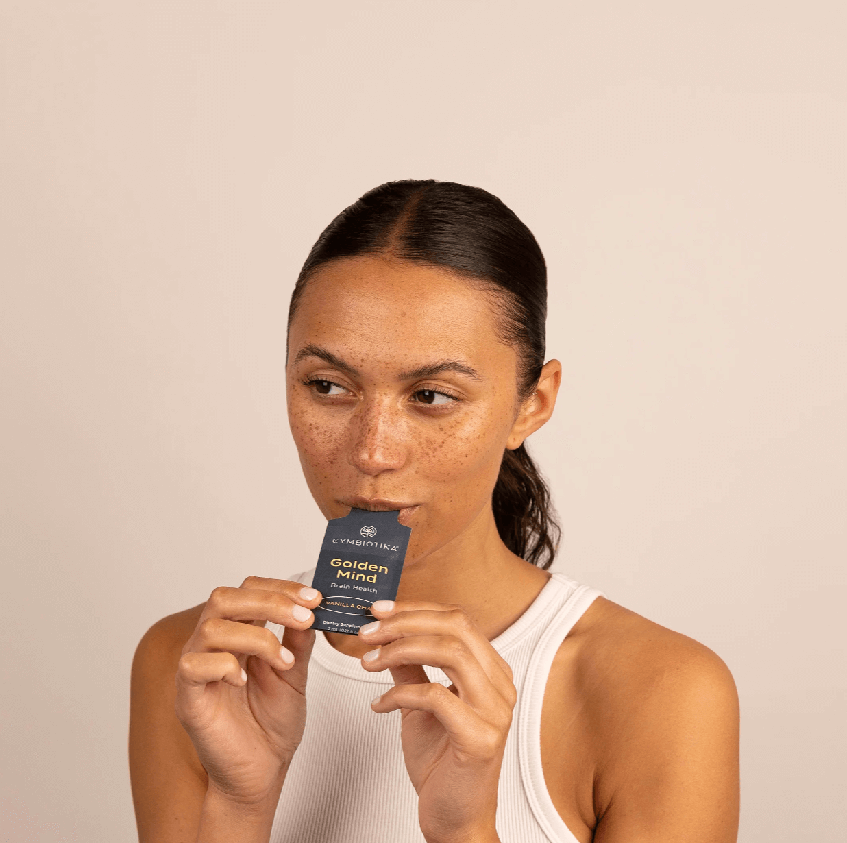 Image of Woman eating  Cymbiotika Golden Mind Brain Health packets