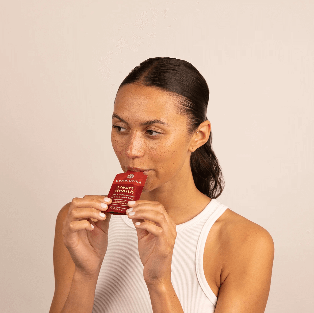 Image of woman eating Cymbiotika Heart Health packets 