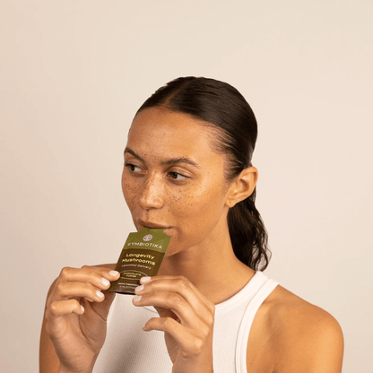 Woman eating Cymbiotika Longevity Mushrooms Chocolate Packets